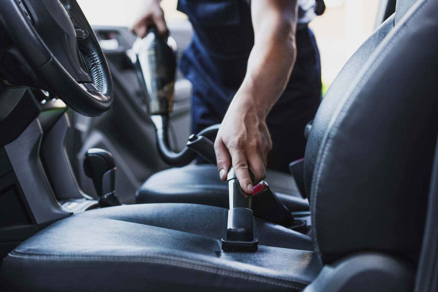 Steam cleaning a black leather car interior